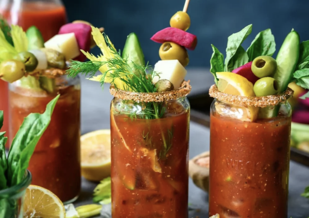 Bloody Mary cocktail garnished with shrimp, pickles, olives, and celery.